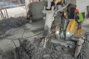 Demolition robot in action to remove tower crane foundation